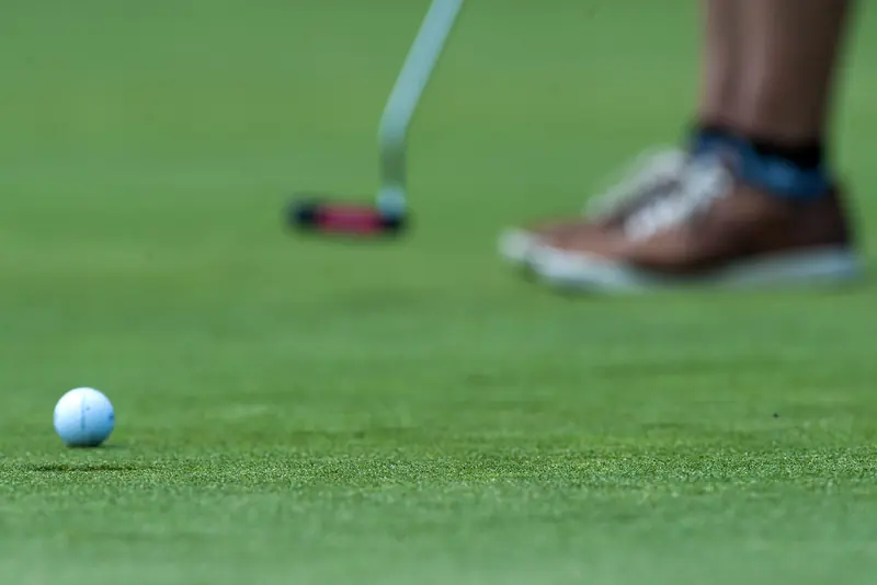 Nahaufnahme eines Putters kurz vor dem Ball